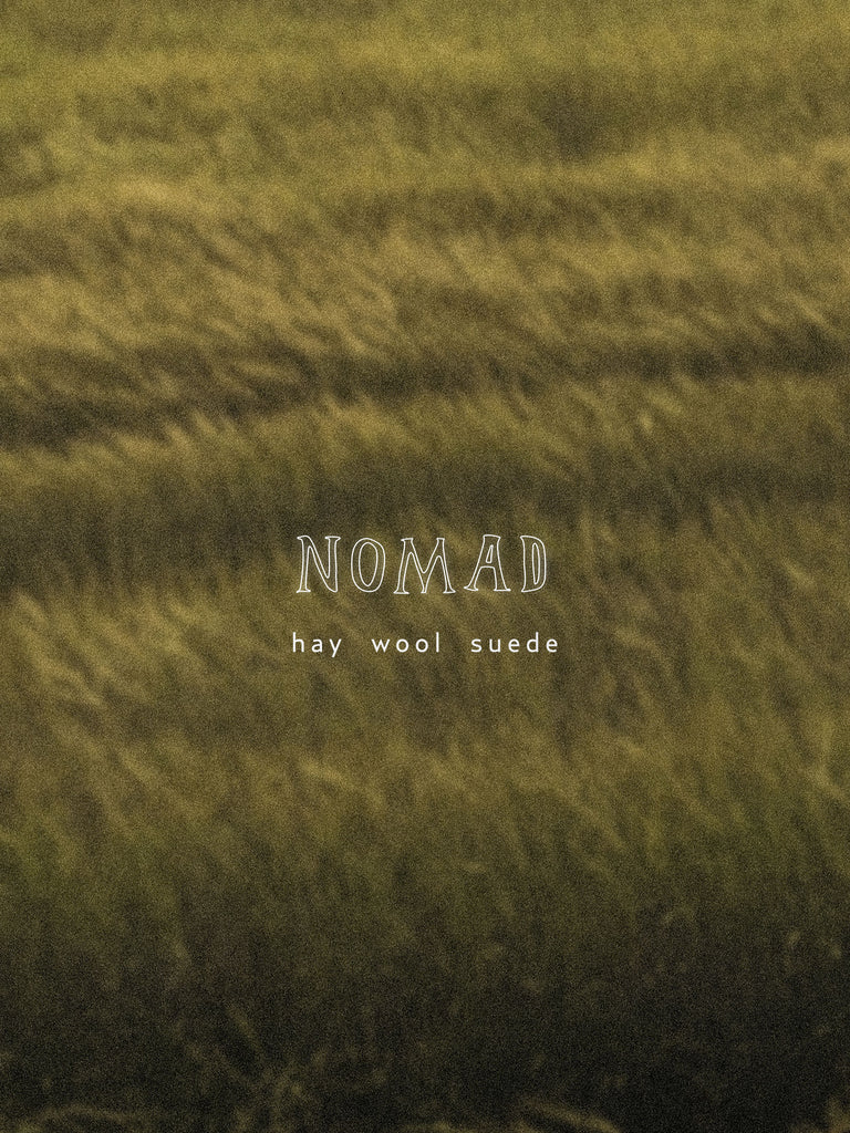 Textured green fabric with 'NOMAD hay wool suede' label
