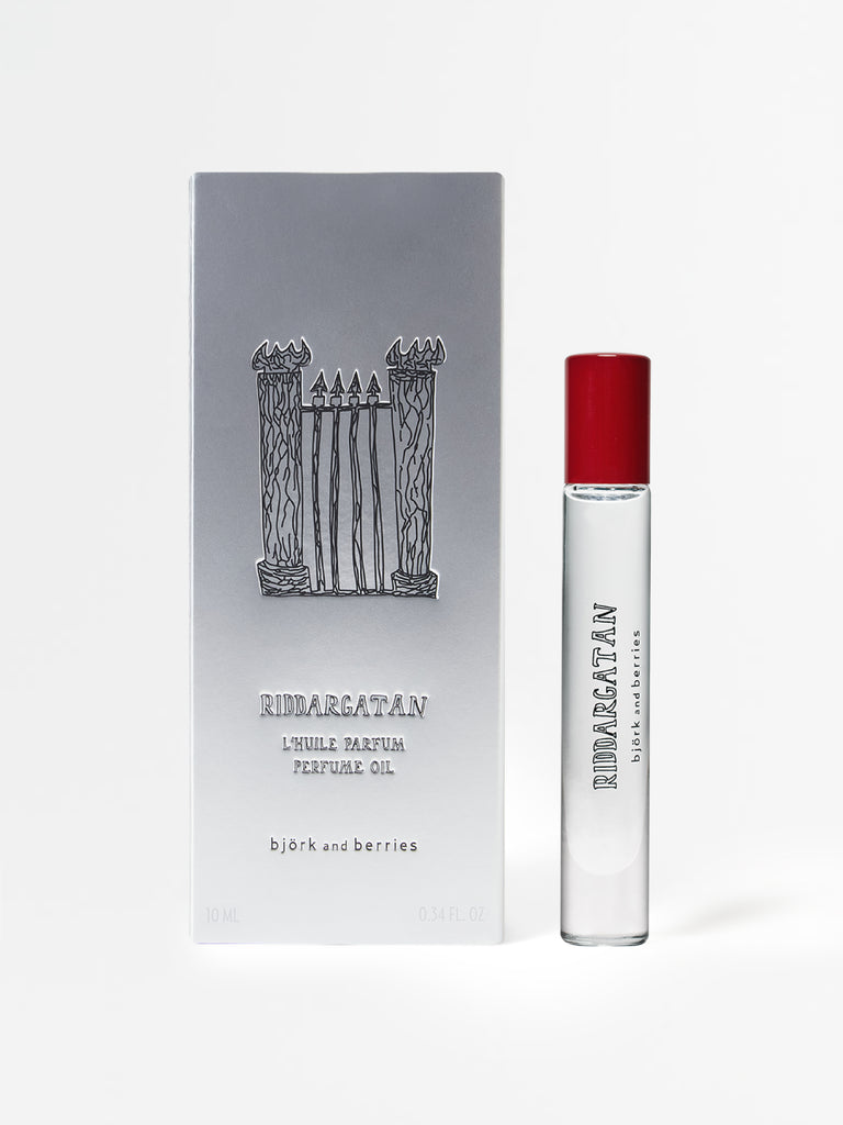 Perfume oil bottle with red cap and gray packaging featuring a black and white illustration on a light gray background